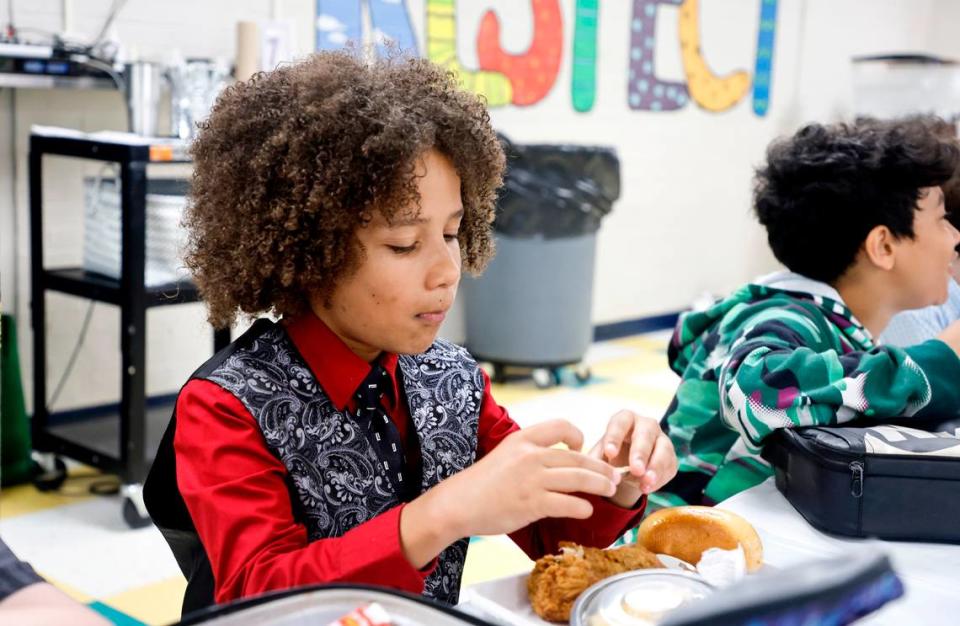 Combs Elementary School fourth grader Trenton Lockwood eats lunch during the Silver Tray lunch at Combs Elementary School in Raleigh, N.C., Thursday, May 16, 2024. At the Silver Tray Luncheon there is fancy silverware, cafeteria tables have tablecloths and centerpieces as the Enloe High School orchestra plays music to provide a fine dining experience. The dining experience was the culmination of a year-long effort to teach Combs’ students about the value of social etiquette and good manners.