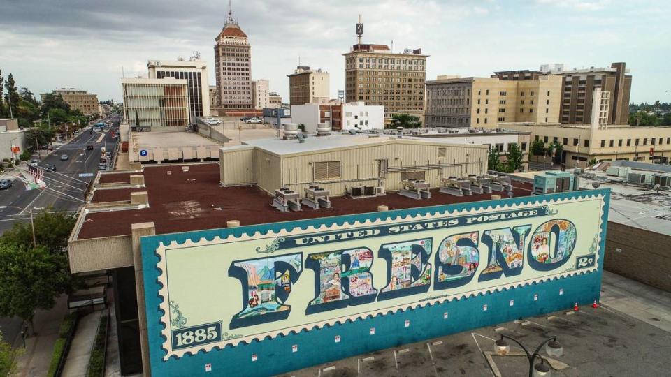 The iconic Fresno postage stamp mural by late Fresno muralist FranCisco Vargas faces north with downtown Fresno behind it on Tuesday, May 30, 2023.