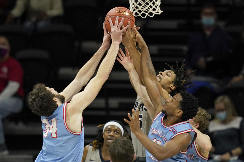 Lewis-Clark State forward Jake Albright (34) and guard Damek Mitchell, right, rebounds against Shawnee State forward Latavious Mitchell, back, during the first half of an NAIA basketball game in the finals of the national tournament in Kansas City, Mo., Tuesday, March 23, 2021. (AP Photo/Orlin Wagner)