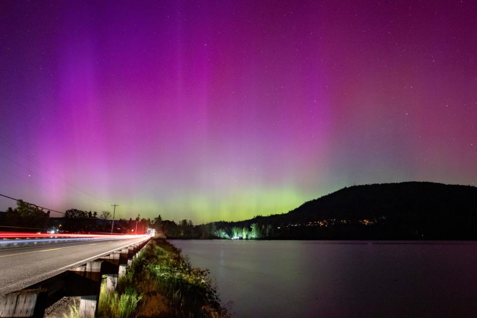 The northern lights appear over Dexter Reservoir before midnight on Friday, May 10, 2024 in Lowell, Ore.