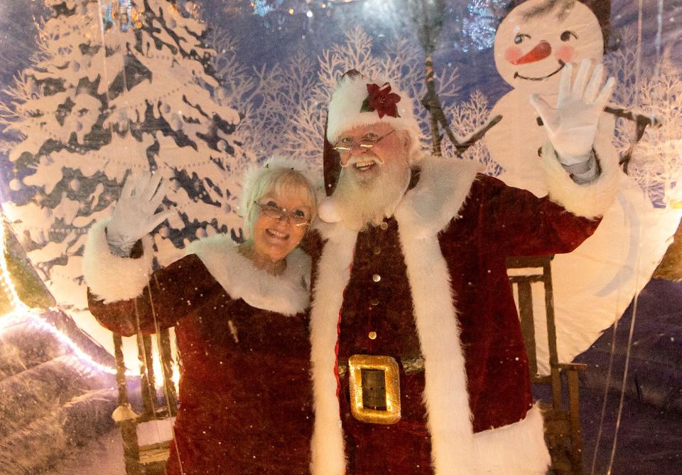 Santa Claus and Mrs. Claus wave from inside a giant inflatable snow globe during the City of Lakeland's 40th Annual Snowfest at the Lake Mirror Promenade Friday night. December 4, 2020.