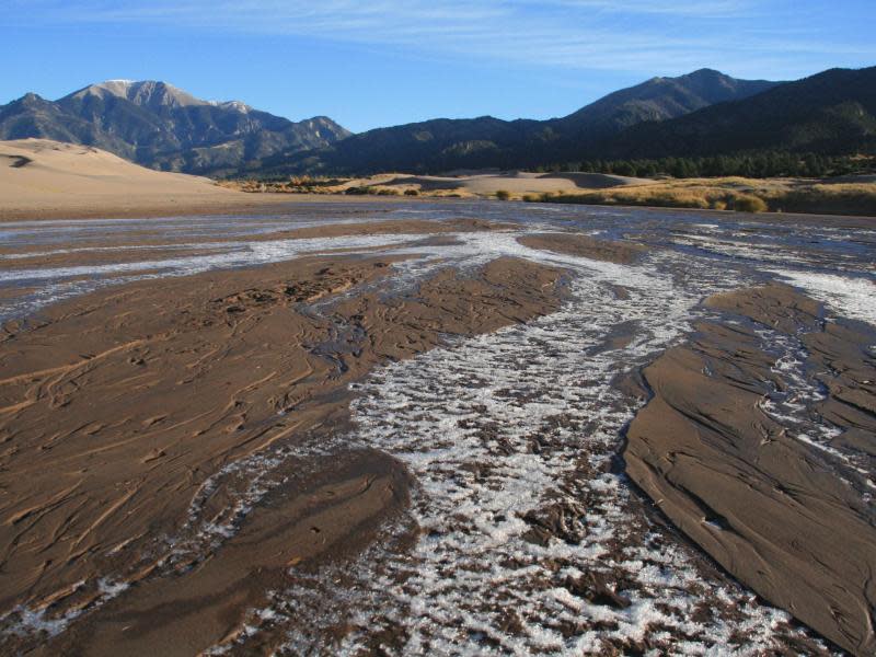 Auf dem Weg zu den Dünen im Great Sand Dunes National Park muss der flache, aber breite Medano Creek überwunden werden. Foto: Stefan Weißenborn