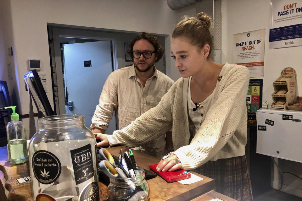 In this photo taken Sept. 20, 2019, David Alport, owner of the Bridge City Collective marijuana dispensary in Portland, Ore., goes over sales numbers with the store's general manager Cameron Moore. The company has seen a 31% decrease in its sales of vaping products in the past two weeks. “It’s having an impact on how consumers are behaving,” said Alport. “People are concerned, and we’re concerned.” (AP Photo/Gillian Flaccus)