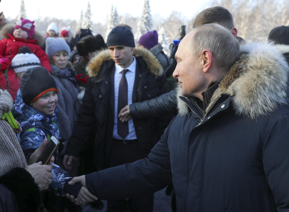 Russian President Vladimir Putin, right, shakes hands with a boy after taking part at a wreath laying ceremony at the Piskaryovskoye Cemetery, in St. Petersburg, Russia, Sunday, Jan. 27, 2019, where most of the Leningrad Siege victims were buried during World War II. The Russian city of St. Petersburg marked the 75th anniversary of the end of the World War II siege by Nazi forces. The siege of the city, then called Leningrad, lasted nearly two and a half years until the Soviet Army drove the Nazis away on Jan. 27, 1944. (Mikhail Klimentyev, Sputnik, Kremlin Pool Photo via AP)