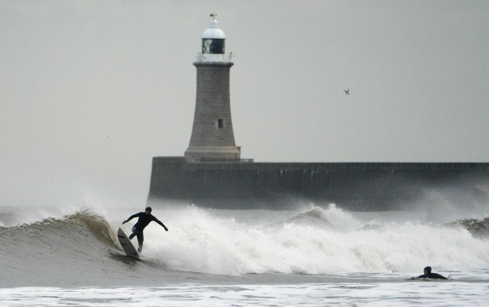 Surfers take on the waves at Tynemouth, north-east England, as the weather is predicted to get much colder over the coming days, Wednesday Jan. 16, 2019. Britain's Met Office has issued a yellow warning for snow and ice over parts of Scotland and northern England, as temperatures are predicted to drop overnight. (Humphreys/PA via AP)