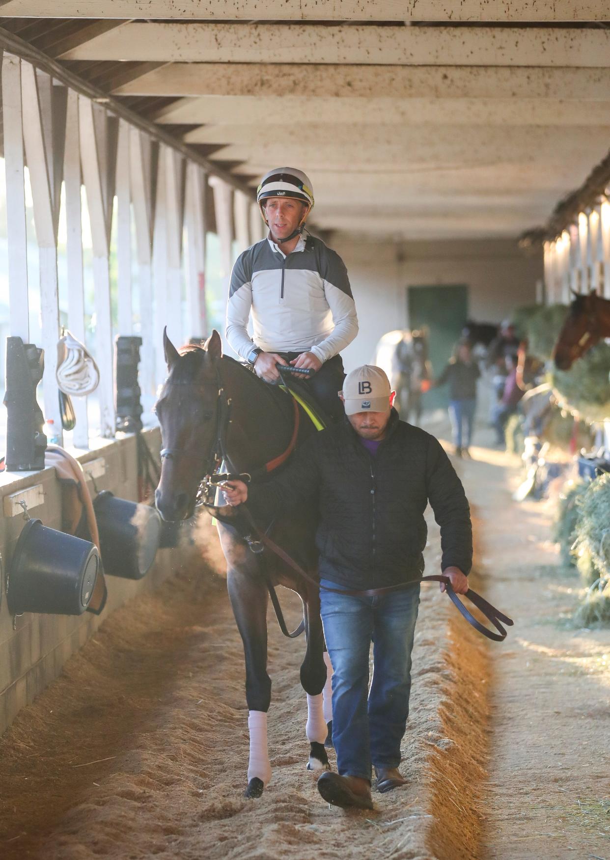 Kentucky Derby 150 contender Honor Marie, trained by Whit Beckman, walks around the barn with jockey Ben Curtis before Curtis' first workout with the colt April 25 at Churchill Downs.