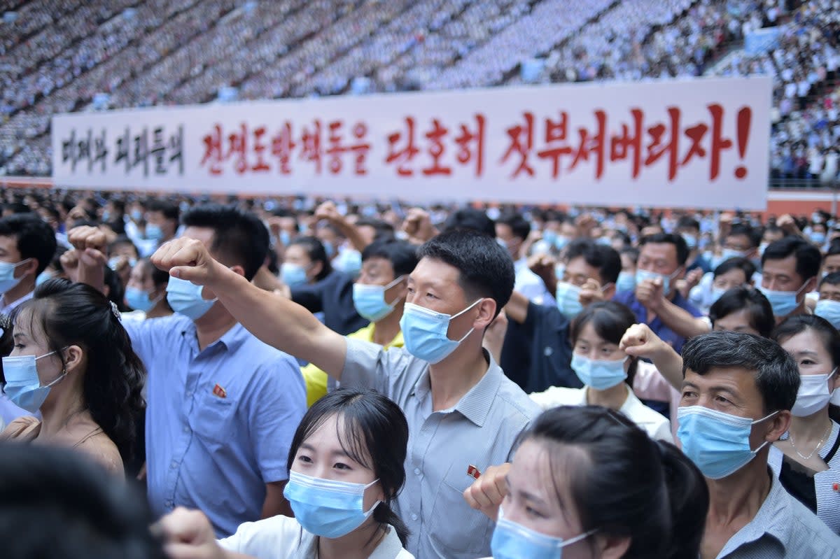 residents of Pyongyang hold a banner that reads "Let us smash down the war provocation of US imperialists and puppets!" (AFP via Getty Images)