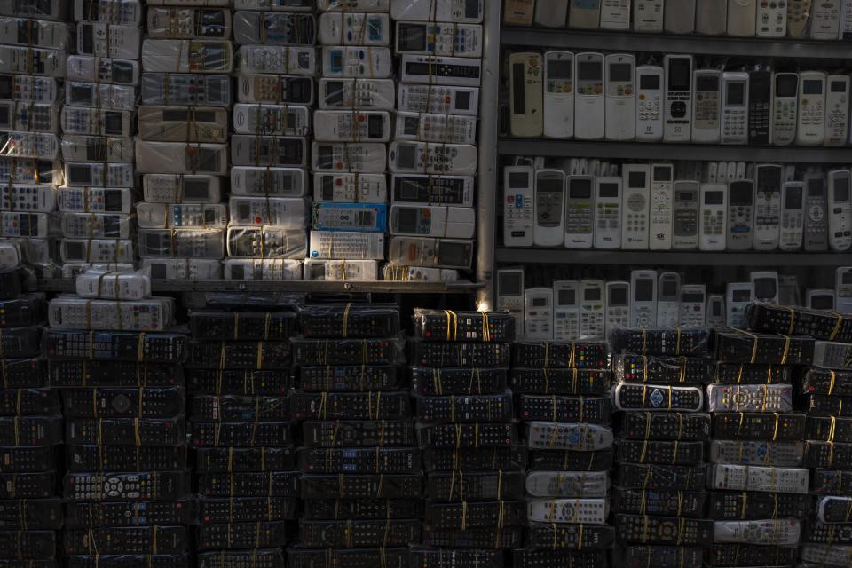 Used remote controls for various home appliances are lit by afternoon sunlight in Nhat Tao market, the largest informal recycling market in Ho Chi Minh City, Vietnam, Sunday, Jan. 28, 2024. (AP Photo/Jae C. Hong)