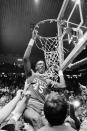 FILE - In this April 4, 1983, file photo, North Carolina State center Cozell McQueen goes after the net during the victory celebration after defeating Houston 54-52 to win the NCAA college basketball championship in Albuquerque, N.M. (AP Photo/File)