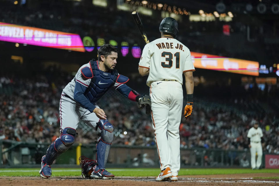 Atlanta Braves catcher Travis d'Arnaud, left, tags San Francisco Giants' LaMonte Wade Jr. (31), who struck out swinging during the fourth inning of a baseball game in San Francisco, Monday, Sept. 12, 2022. (AP Photo/Godofredo A. Vásquez)