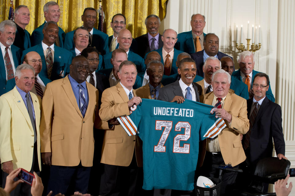 FILE- Former Miami Dolphin's quarterback Bob Griese, left, holds a signed jersey with President Barack Obama and Hall of Fame coach Don Shula, forty-one years after their perfect football season as President Barack Obama honors the Super Bowl VII Champion Miami Dolphins in the East Room of the White House in Washington, Tuesday, Aug. 20, 2013. The 1972 Miami Dolphins remain the only undefeated team in NFL history. (AP Photo/Jacquelyn Martin, File)