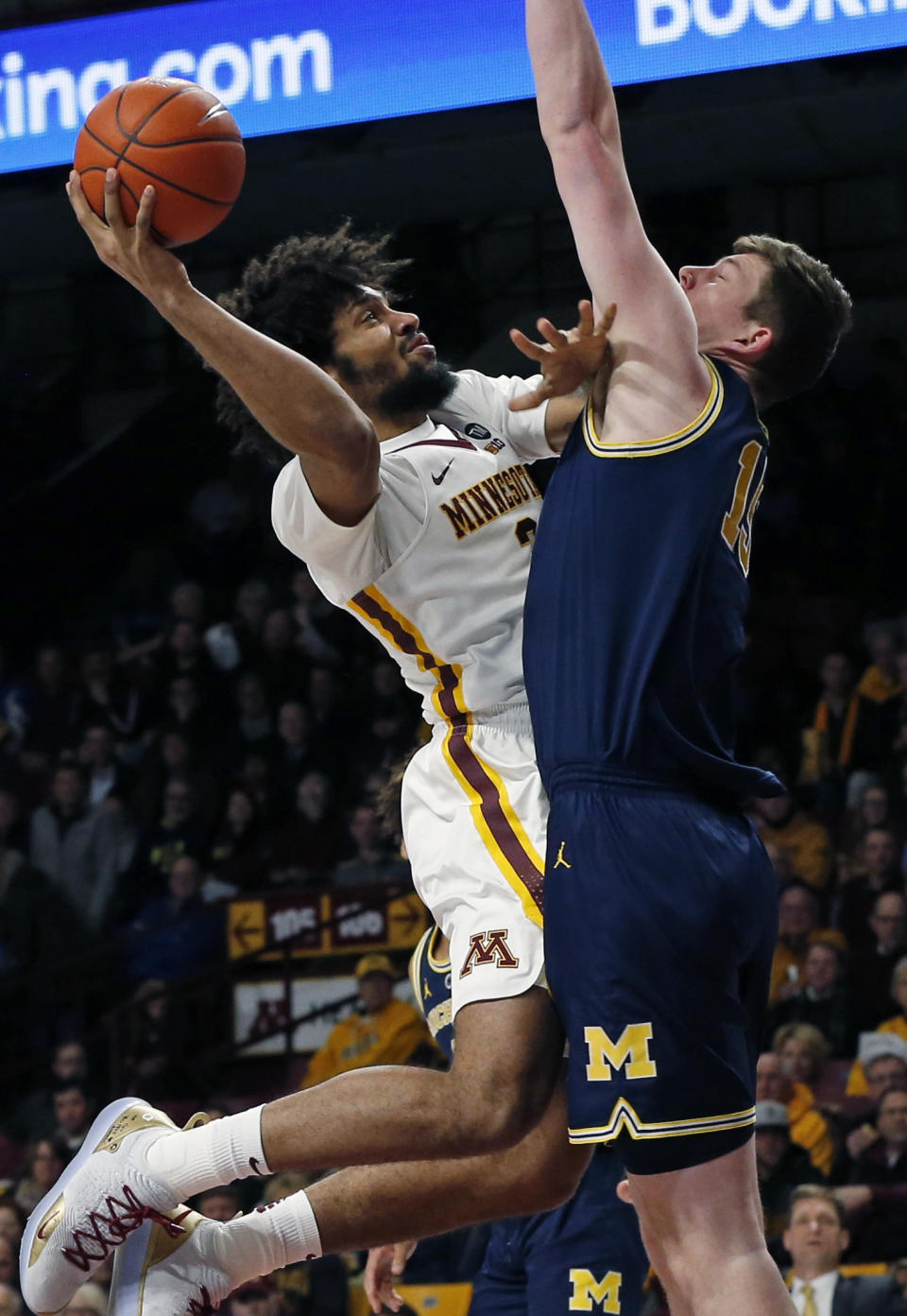 Minnesota's Jordan Murphy, left, goes for a layup as Michigan's Jon Teske tries to block the shot in the first half of an NCAA college basketball game Thursday, Feb. 21, 2019, in Minneapolis. (AP Photo/Jim Mone)