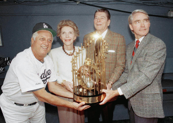 Dodgers manager Tommy Lasorda, left, shares one of the Los Angeles Dodgers&#39; World Championship trophies with former President Ronald Reagan, Nancy Reagan, and Dodgers executive vice-president Fred Claire, right, before home opener at Dodger Stadium in Los Angeles on April 13, 1989. (Reed Saxon / AP file)