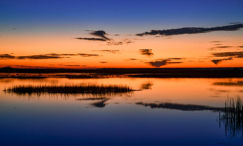 Morning glow in orange and blue shortly before sunrise on the Copahee Sound in Mount Pleasant, South Carolina. - Photo: Glenn Ross Images (Getty Images)