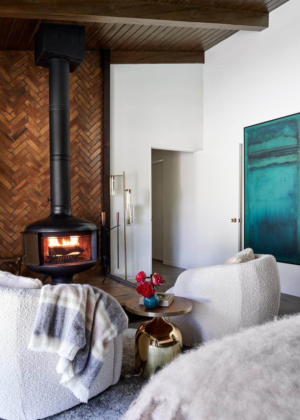 Comfort is the name of the game in Colman and Raúl’s main bedroom. CB2 accent chairs sit directly in front of a cozy indoor fireplace, courtesy of the original homeowners.