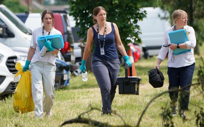 Police forensic investigators examine the scene - Lucy North/PA