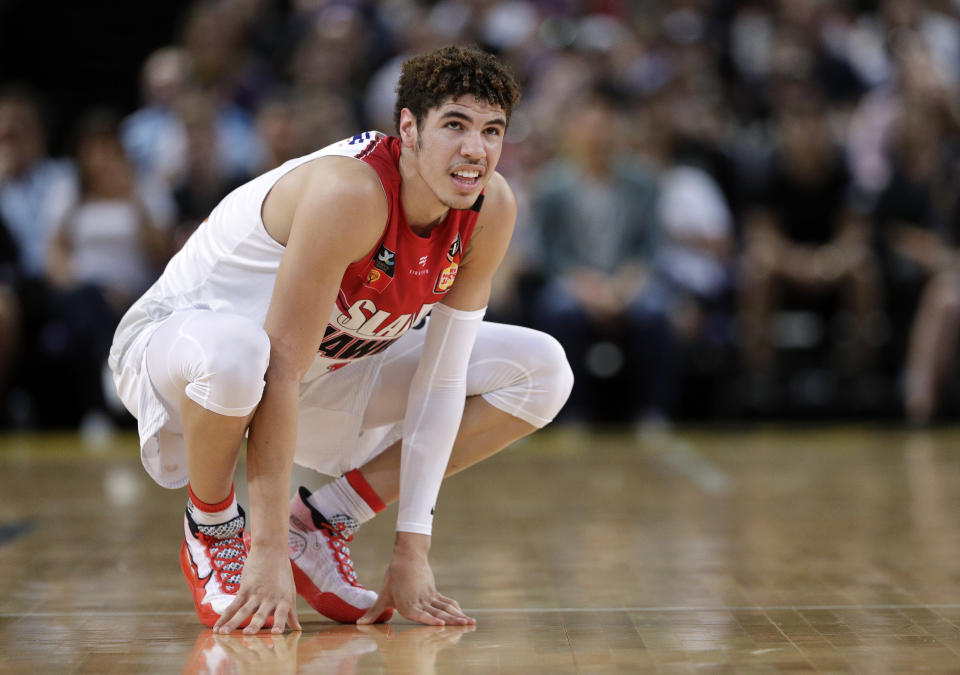 FILE- In this Nov. 17, 2019, file photo, LaMelo Ball of the Illawarra Hawks squats during their game against the Sydney Kings in the Australian Basketball League in Sydney. The point guard from California who bypassed college and played overseas is expected to be one of the top picks when the twice-delayed NBA draft is held in November. (AP Photo/Rick Rycroft, File)