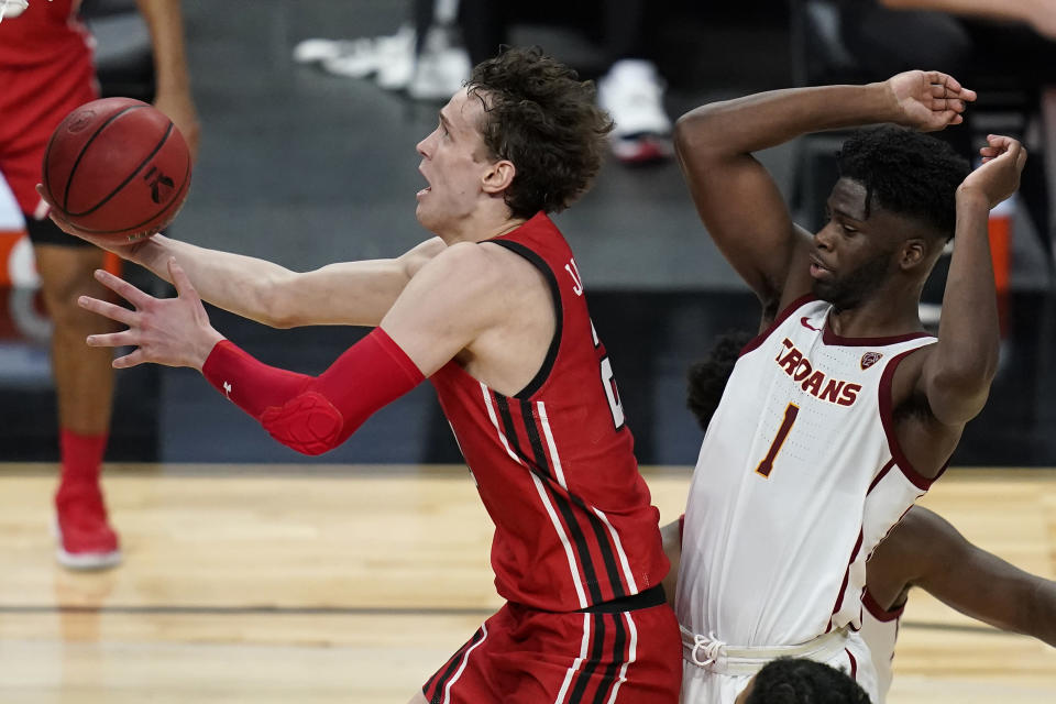 Utah's Mikael Jantunen (20) shoots around Southern California's Chevez Goodwin (1) during the first half of an NCAA college basketball game in the quarterfinal round of the Pac-12 men's tournament Thursday, March 11, 2021, in Las Vegas. (AP Photo/John Locher)