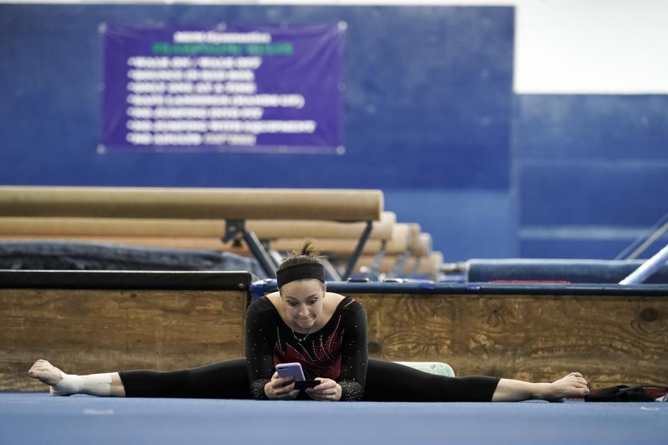 Chellsie Memmel works out Thursday, Feb. 18, 2021, in New Berlin, Wisc. Memmel started doing gymnastics again when the COVID-19 pandemic hit last spring because it felt like one of the few things in her life she could control. The 32-year-old former world champion and Olympic silver medalist discovered more than an outlet for stress. She rediscovered her love for the sport, so much so the married mother of two is making an unlikely comeback. (AP Photo/Morry Gash)