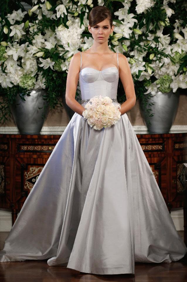 This photo released by Romona Keveza shows a sleeveless Romona Keveza Coutour wedding dress. The traditional bridal gown isn't a skimpy silhouette: It's long and typically without a plunging neckline or high slit. There's often a whole lot of fabric. One of the few opportunities for brides to be a little bare is to go with a strapless or sleeveless dress. New bridal collections are dominated by dresses with no sleeves. (AP Photo/Romona Keveza)