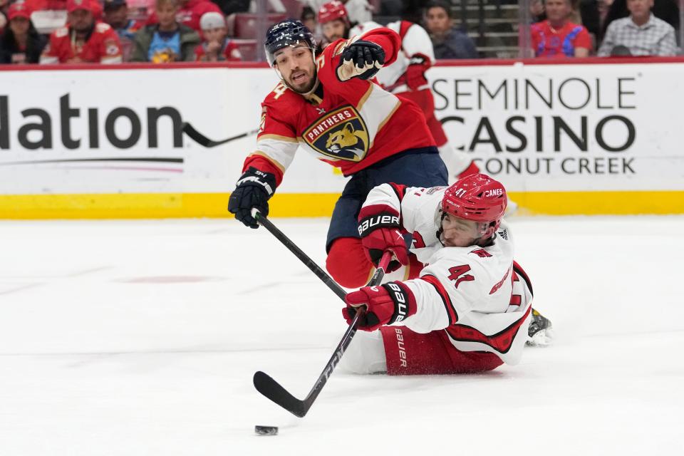 Florida Panthers left wing Ryan Lomberg (94) defends as Carolina Hurricanes defenseman Shayne Gostisbehere (41) reaches for the puck during the second period of an NHL hockey game Thursday, April 13, 2023, in Sunrise, Fla.