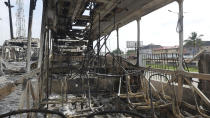 Burnt out government transportation buses at the Berger station near Ikeja, Lagos, Nigeria, Thursday, Oct. 22, 2020. Lagos streets were empty and shops were shuttered Thursday, as residents of Nigeria's largest city obeyed the government's curfew, stopping the protests against police brutality that had lasted for two weeks. The #EndSARS demonstrations began in early October with calls for Nigeria’s government to shut down the police Special Anti-Robbery Squad, known as SARS. (AP Photo)