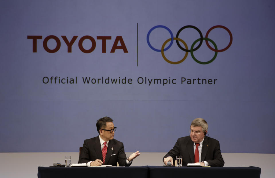 FILE - International Olympic Committee (IOC) Thomas Bach, right, and Toyota President and CEO Akio Toyoda attend a press conference in Tokyo, on March 13, 2015. Toyota will end its massive sponsorship deal with the International Olympic Committee after this year's Paris Olympics, according to reports in Japan. (AP Photo/Eugene Hoshiko, File)