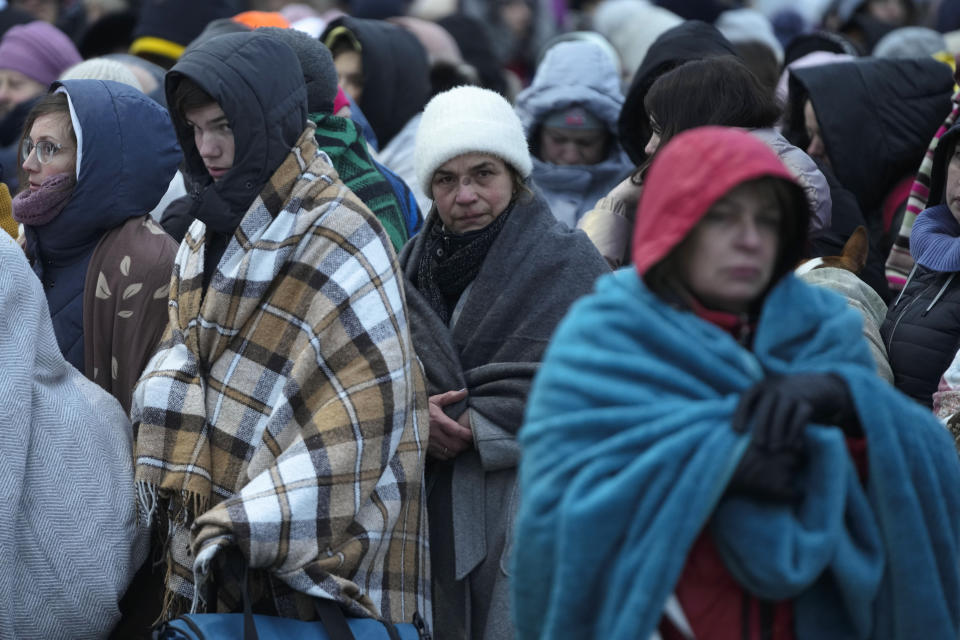 FILE - Refugees, mostly women and children, wait in a crowd for transportation after fleeing from the Ukraine and arriving at the border crossing in Medyka, Poland, on March 7, 2022. The U.N. refugee agency says more than 4 million refugees have now fled Ukraine following Russia’s invasion, a new milestone in the largest refugee crisis in Europe since World War II. (AP Photo/Markus Schreiber)