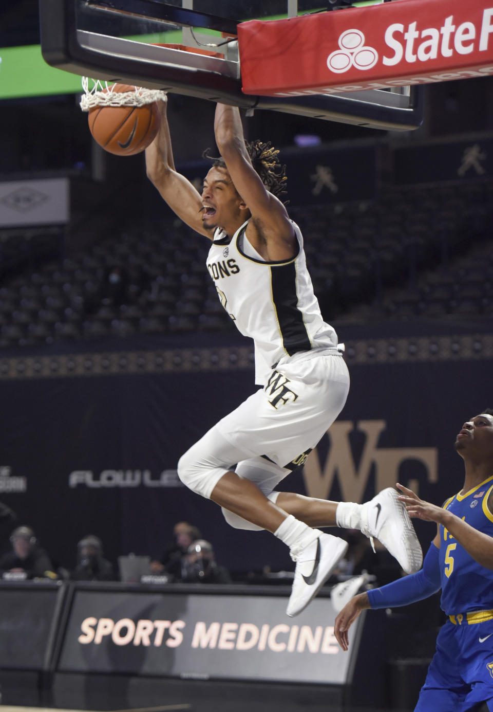 Wake Forest's Jalen Johnson gets past Pittsburgh's Au'diese Toney for a dunk during an NCAA college basketball game Saturday, Jan. 23, 2021, in Winston-Salem, N.C. (Walt Unks/The Winston-Salem Journal via AP)