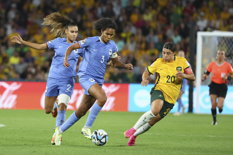 Australia's Sam Kerr, right, challenges for the ball with France's Wendie Renard, centre, during the Women's World Cup quarterfinal soccer match between Australia and France in Brisbane, Australia, Saturday, Aug. 12, 2023. (AP Photo/Tertius Pickard)