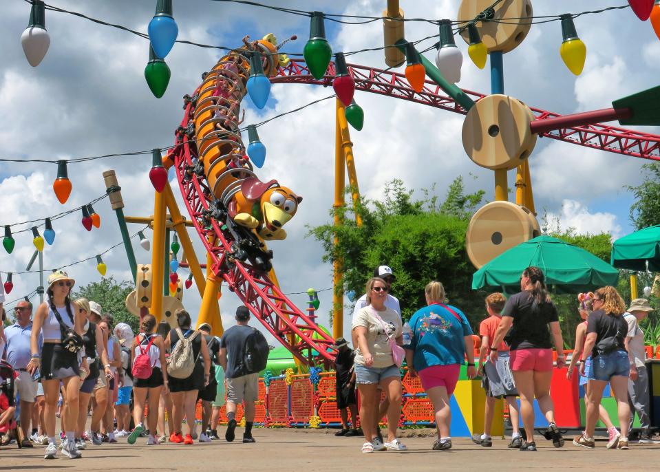 Guests walk past the Slinky Dog Dash Roller Coaster at Toy Story Land at Disney's Hollywood Studios, Walt Disney World, on July 19, 2023