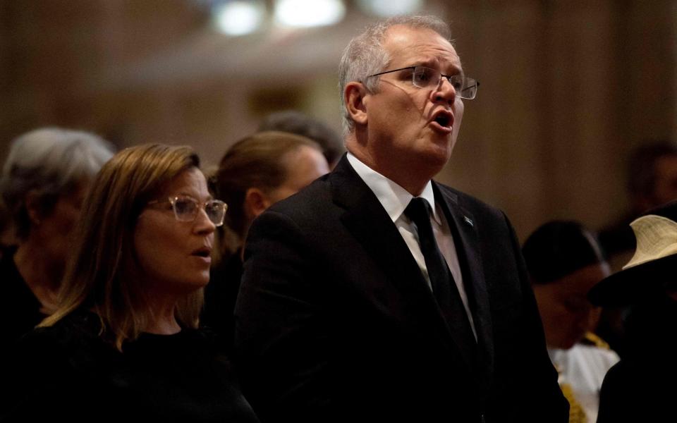 Australia's Prime Minister Scott Morrison (R) and his wife Jenny Morrison (L) sing during a prayer service - Bianca de Marchi/AFP