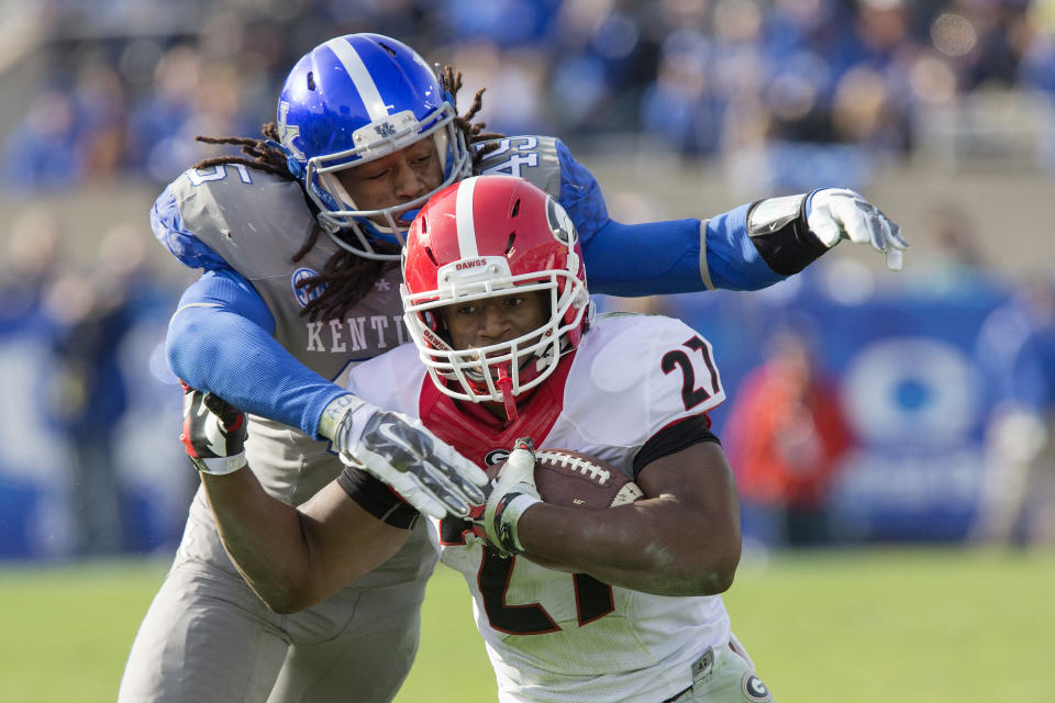 Georgia running back Nick Chubb gets wrapped up by Kentucky linebacker Josh Forrest during the second half of an NCAA college football game at Commonwealth Stadium in Lexington, Ky., Saturday, Nov. 8, 2014. Georgia beat Kentucky 63-31. (AP Photo/David Stephenson)