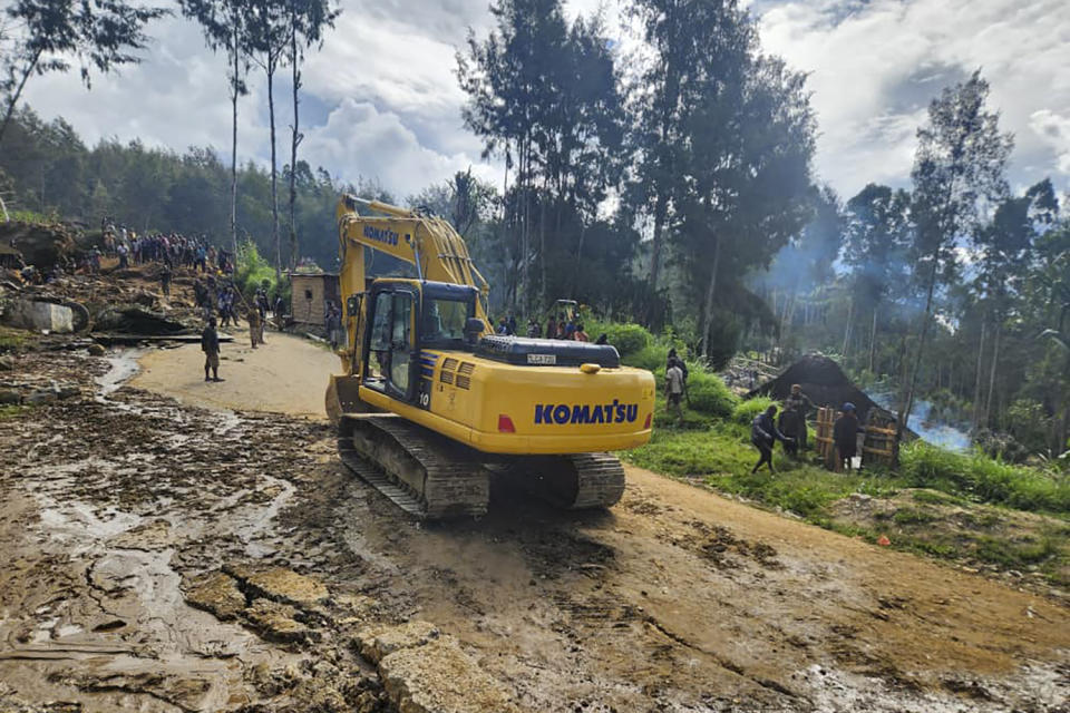 Villagers use heavy machinery to search through a landslide in Yambali in the Highlands of Papua New Guinea, Sunday, May 26, 2024. The International Organization for Migration feared Sunday the death toll from a massive landslide is much worse than what authorities initially estimated. (Mohamud Omer/International Organization for Migration via AP)