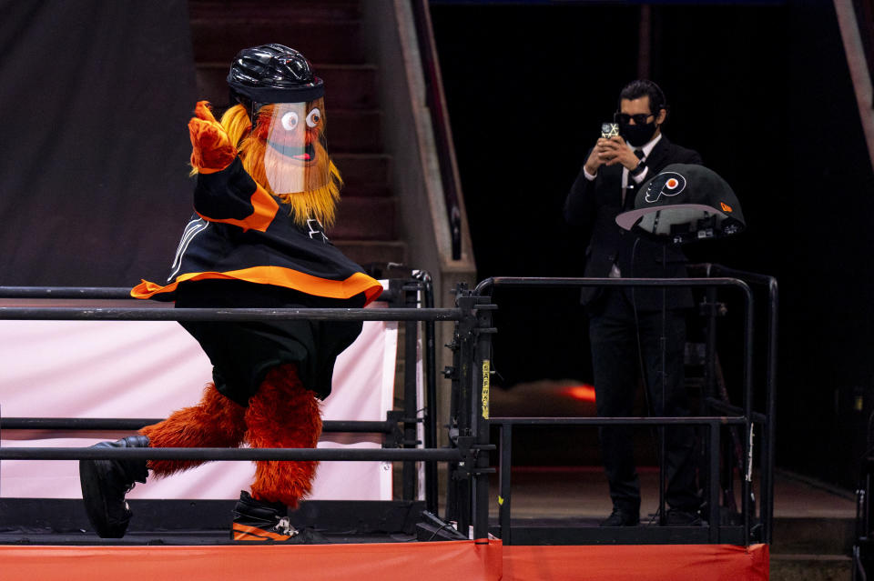 Philadelphia Flyers mascot Gritty tosses a large cap onto the ice for Travis Konecny's third goal of an NHL hockey game during the third period against the Pittsburgh Penguins, Friday, Jan. 15, 2021, in Philadelphia. (AP Photo/Chris Szagola)