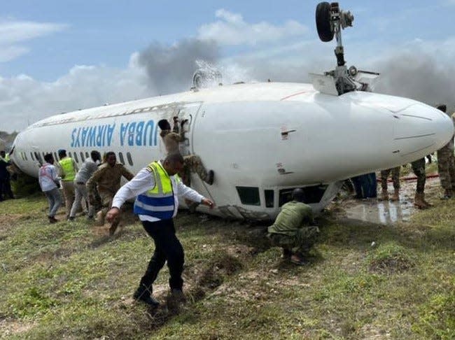 Three Fort Bragg soldiers with the  2nd Security Force Assistance Brigade help first responders and Somalia Danab brigade commandos care for injured passengers, after a Jubba Airlines aircraft crash-landed Monday, July 18, 2022, at Mogadishu International Airport in Mogadishu, Somalia.