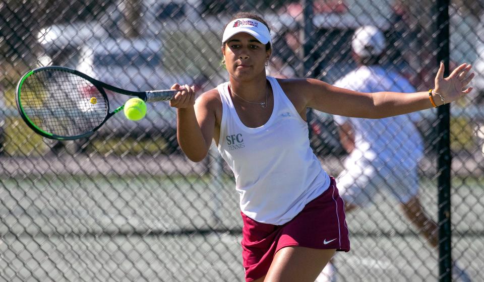 Santa Fe Catholic junior Nya Kerr hits a forehand against Windermere Prep's Jiaxu Zhang in the No. 1 singles girls finals of the Class 1A, District 6 tennis tournament at Woodlake Park.