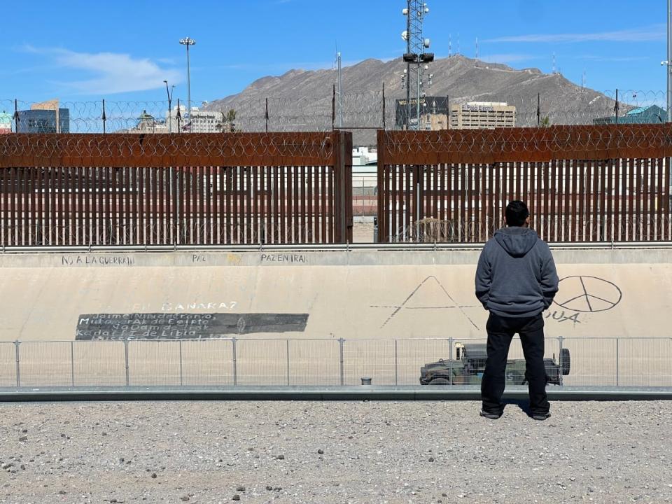 A man in Juarez, Mexico, stands facing the northern U.S. border. Entry into the U.S., be it legally or otherwise, remains extremely complicated and word has spread among migrants that Canada is likely a significantly better landing spot. (Paul Hunter/CBC - image credit)