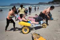 Smyth aims to increase the number of adaptive surfers -- not only showing people with disabilities that surfing is possible, but making it practically accessible to them. Here Alison Edwards, 54, is helped off the beach after a surf