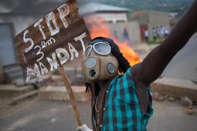A Burundian protester holds a sign "Stop the third mandate" on May 6, 2015 as government and opposition rivals met in a bid to end deadly demonstrations against a third term bid by the president