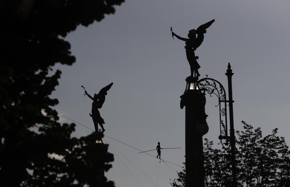 French tightrope walker Tatiana-Mosio Bongoga balances over the Vltava river during her performance to open an international new circus festival in Prague, Czech Republic, Wednesday, Aug. 14, 2019. (AP Photo/Petr David Josek)