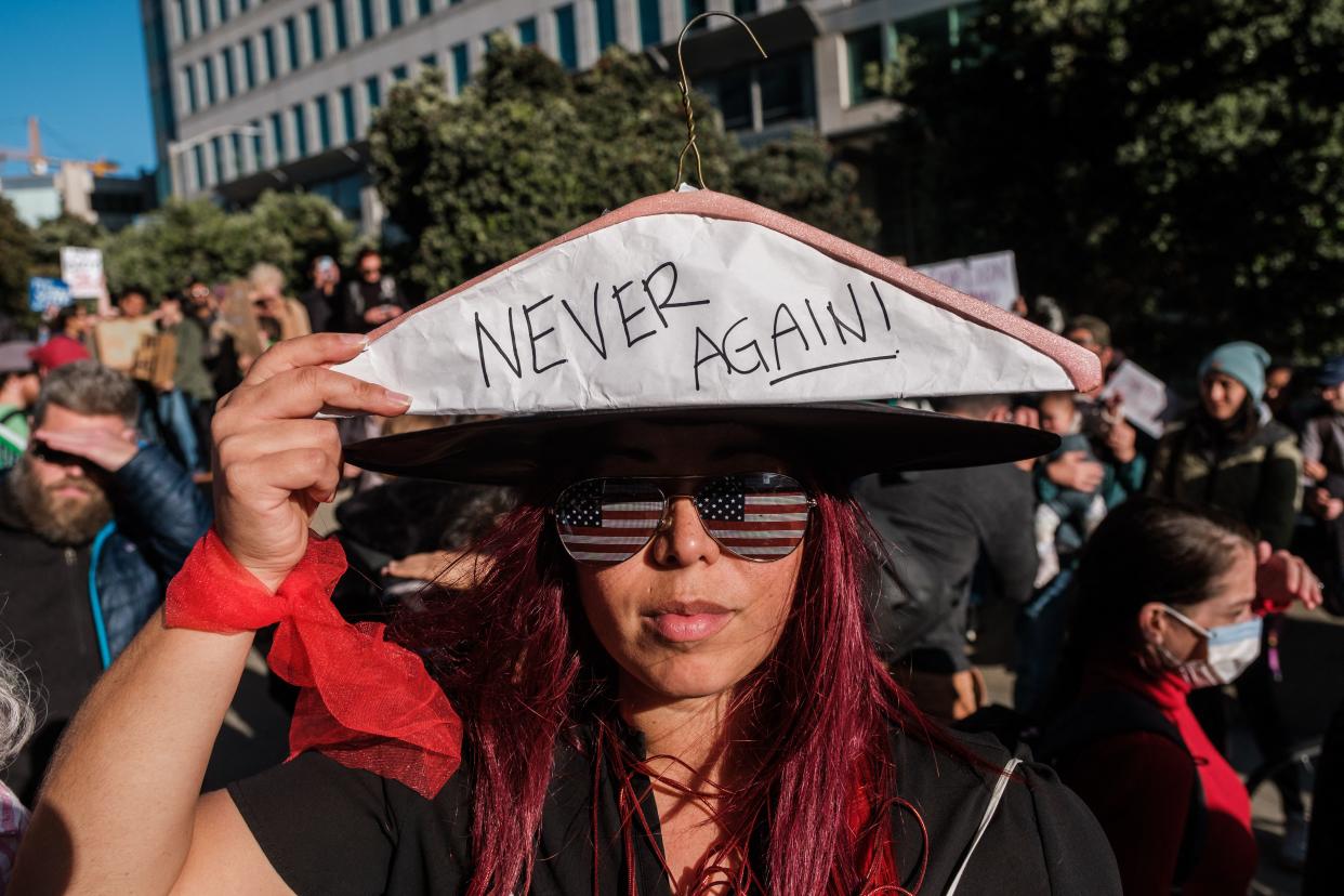 A woman holds up a coat hanger, a symbol of the reproductive rights movement, at an abortion rights rally in San Francisco on Tuesday. (Nick Otto/AFP via Getty Images)