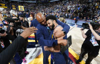 Denver Nuggets assistant coach Popeye Jones, left, hugs guard Jamal Murray after Game 5 of an NBA basketball first-round playoff series against the Los Angeles Lakers Monday, April 29, 2024, in Denver. Murray scored 32 points despite a strained calf and sank the game-winner with 3.6 seconds left to win over the Lakers. (AP Photo/David Zalubowski)