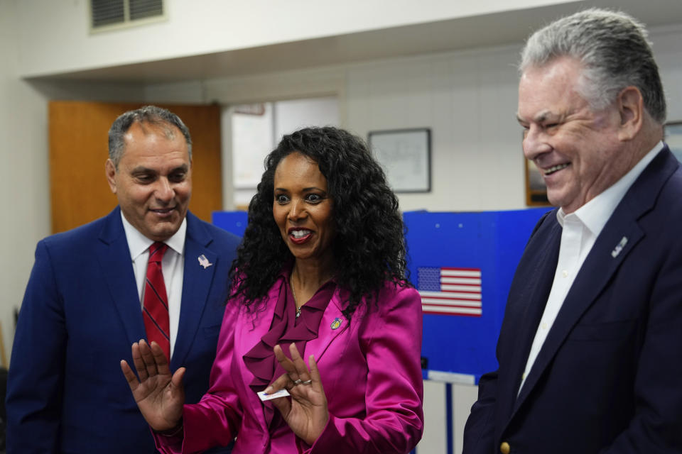 CORRECTS LAST NAME TO PILIP, NOT PHILIP - Mazi Pilip, center, the Republican congressional candidate for New York's 3rd district, reacts as she votes early at a polling station in Massapequa, N.Y., Friday, Feb. 9, 2024. The race to replace disgraced former Rep. George Santos pits Pilip, a Nassau County legislator, against former U.S. Rep. Tom Suozzi, a Democrat who represented the district for three terms before quitting to run for governor. Joining Pilip are, former U.S Rep. Peter King, right, and Oyster Bay, N.Y., Town Supervisor Joseph Saladino. (Adam Gray/Pool Photo via AP)