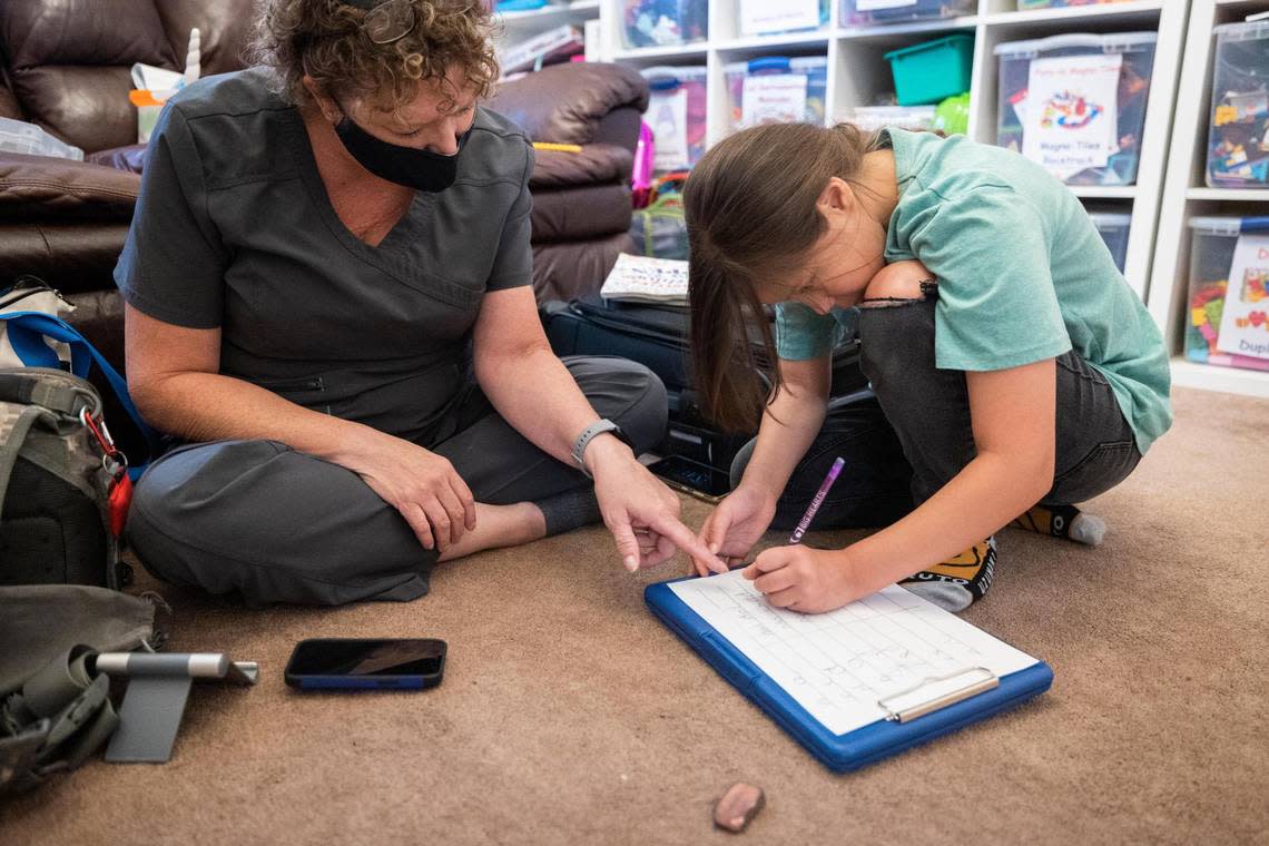 Frida Piñón works on her penmanship with Cody McGrew, occupational therapy assistant.