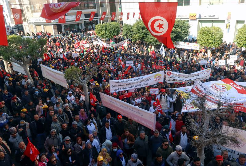 Supporters of the Tunisian General Labour Union (UGTT), carry flags and banners during a protest in Sfax