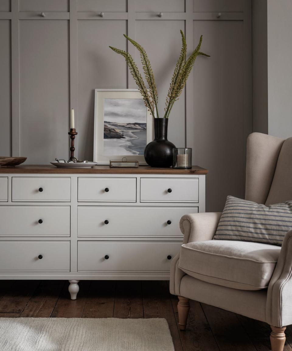 White dresser, armchair, black vase