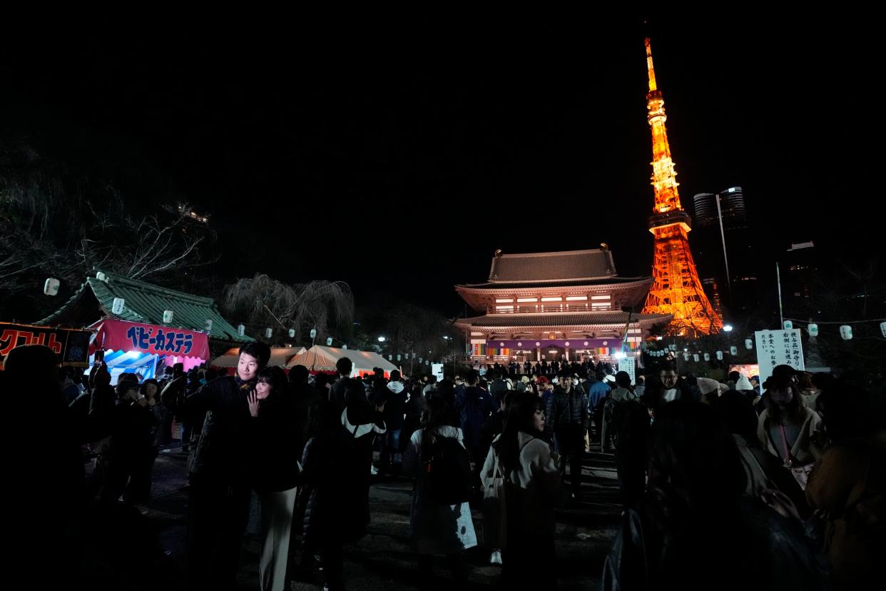 People queue to pray at Zojoji Buddhist temple in Tokyo on New Year’s Eve (AP)