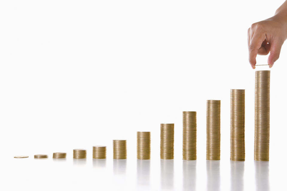 Stacks of coins progressively getting taller, illustrating compound growth.