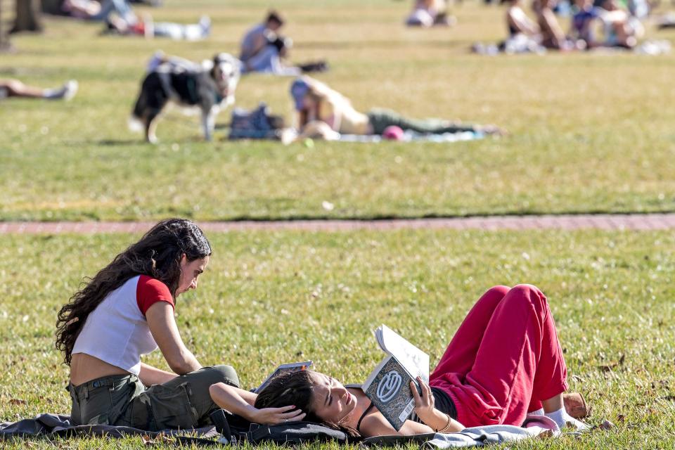 University of Delaware students read and work outdoors on a sunny and warm winter day on The Green in Newark, Thursday, Feb. 23, 2023.